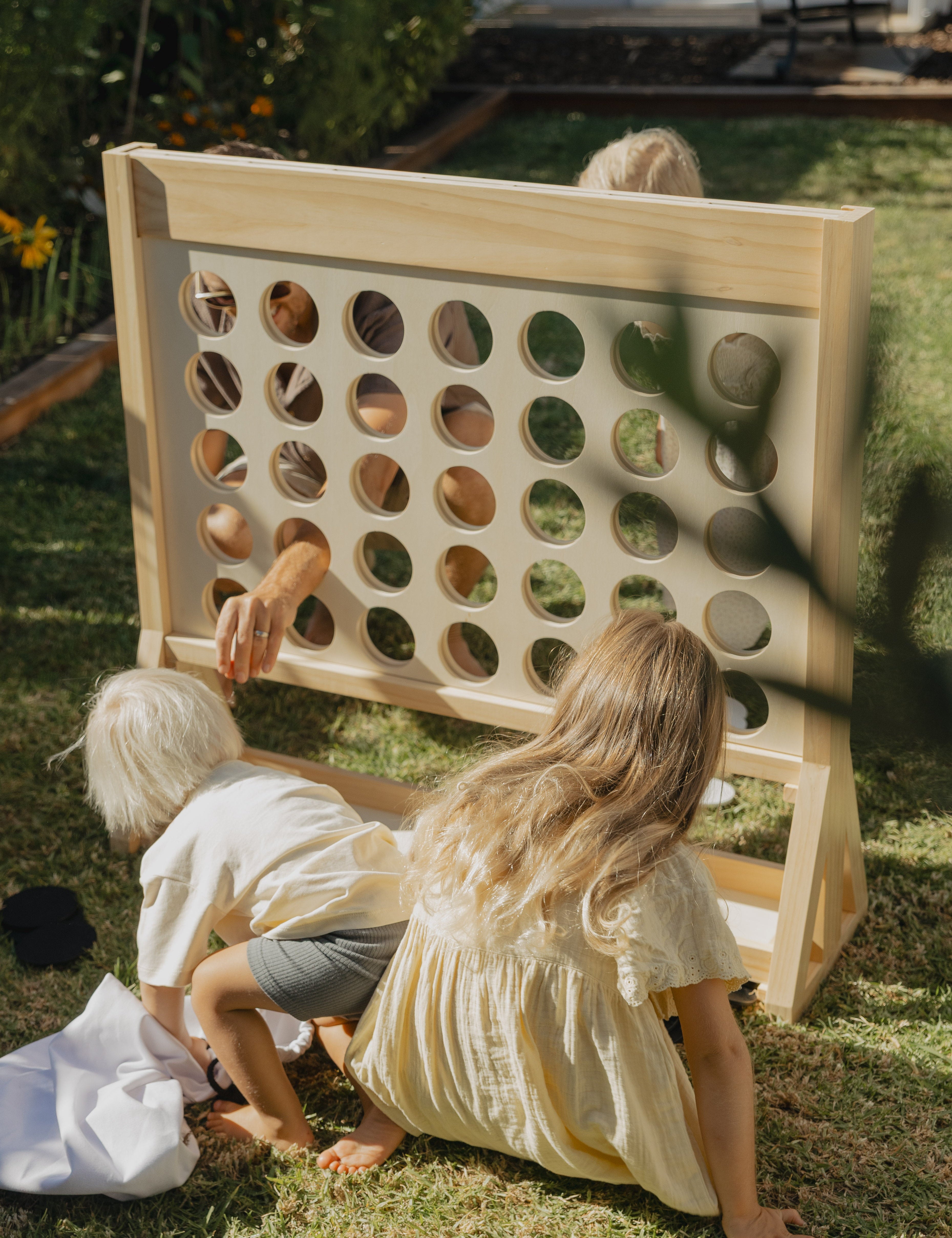family playing Giant Connect Four in backyard