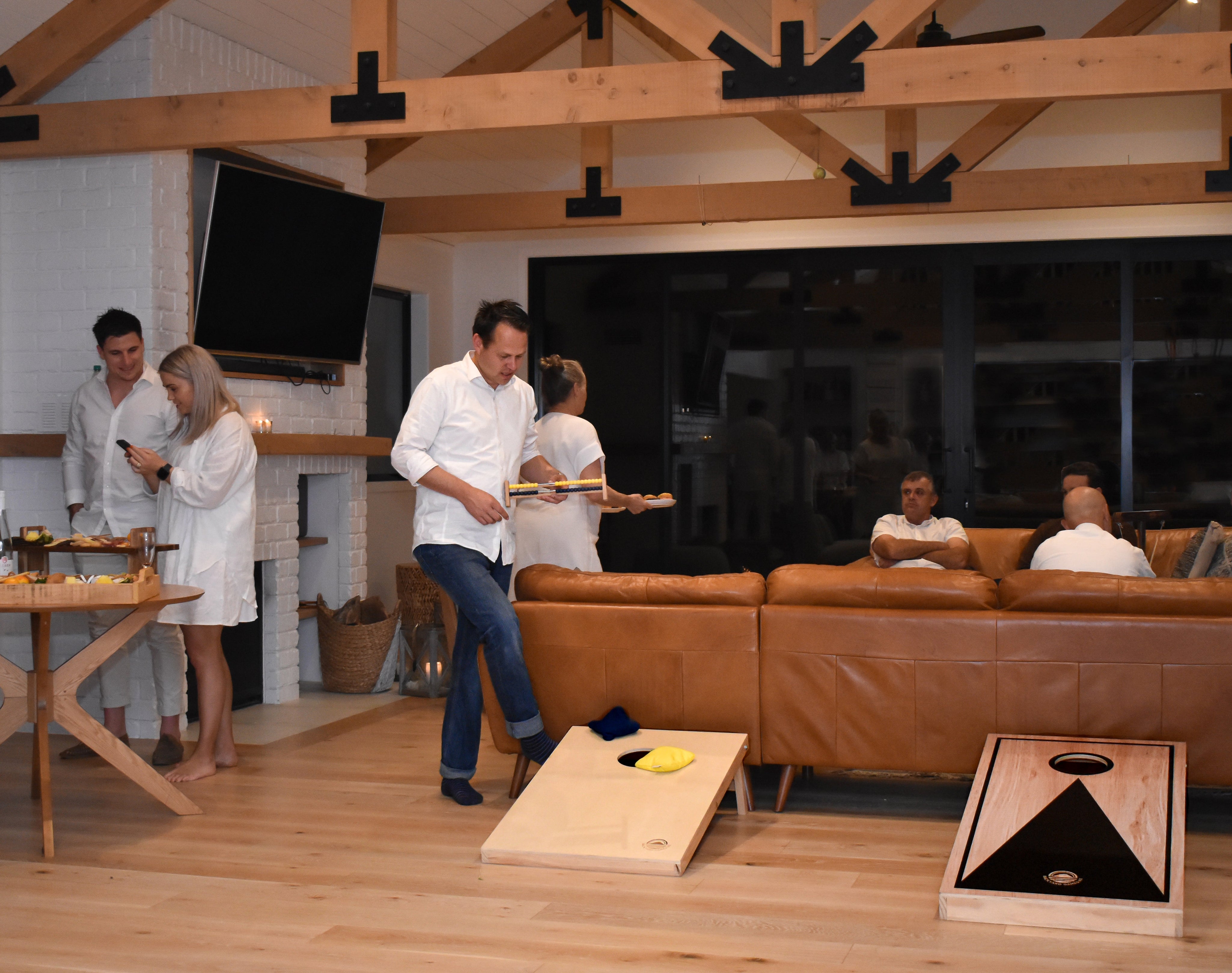 People playing Cornhole indoors