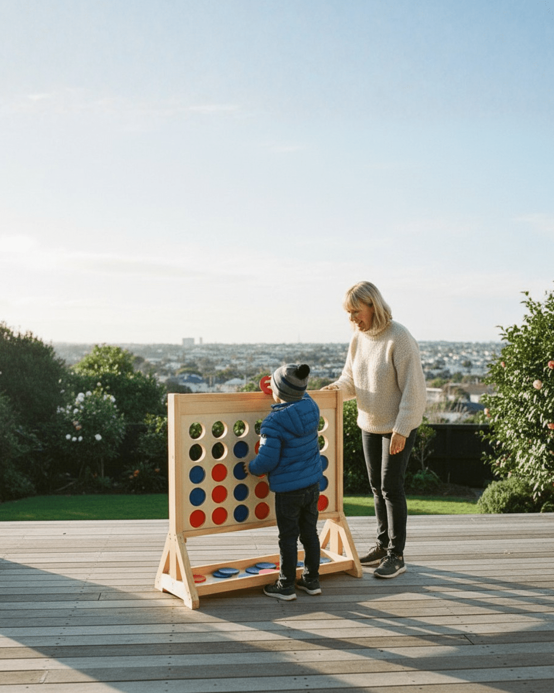 Woman and child playing Giant Connect Four on deck in winter