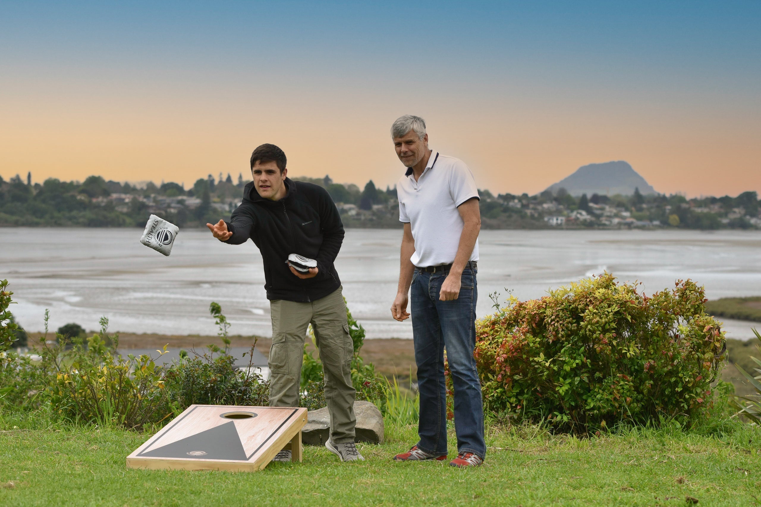 Friends playing gutter board and giant dominoes on a covered deck in New Zealand during autumn