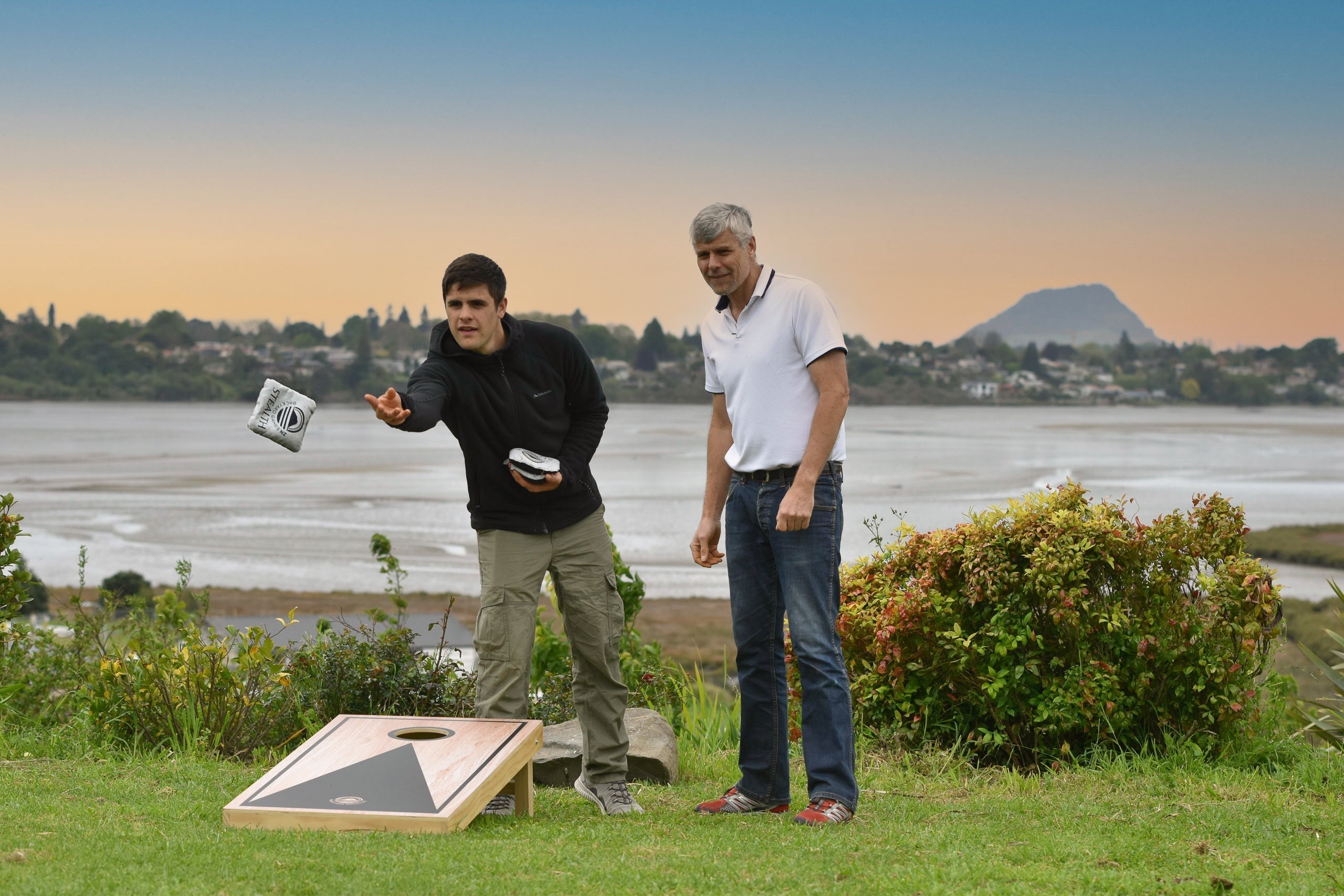 Friends playing gutter board and giant dominoes on a covered deck in New Zealand during autumn