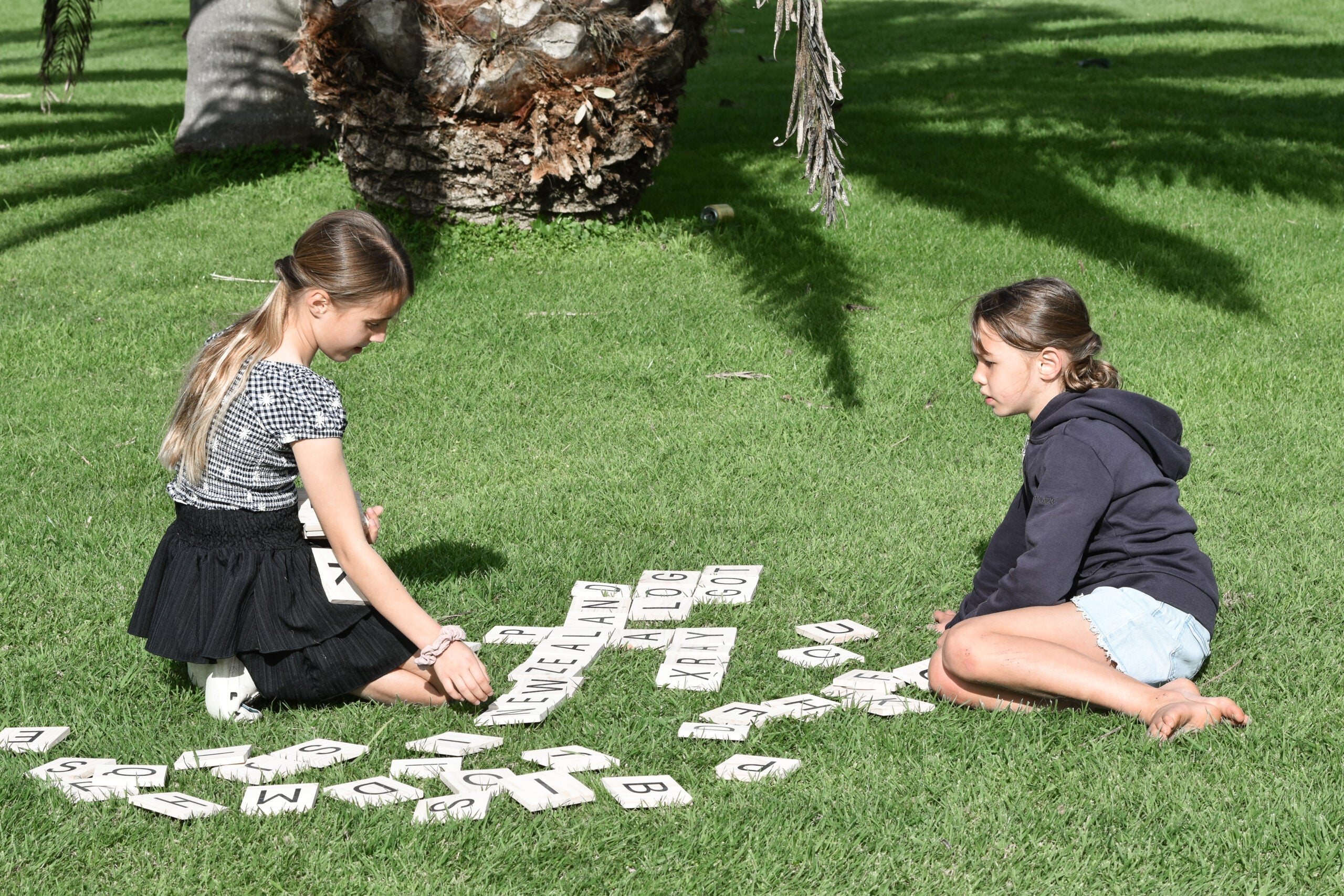 Two girls playing Backyard Games Letter Tiles Outside