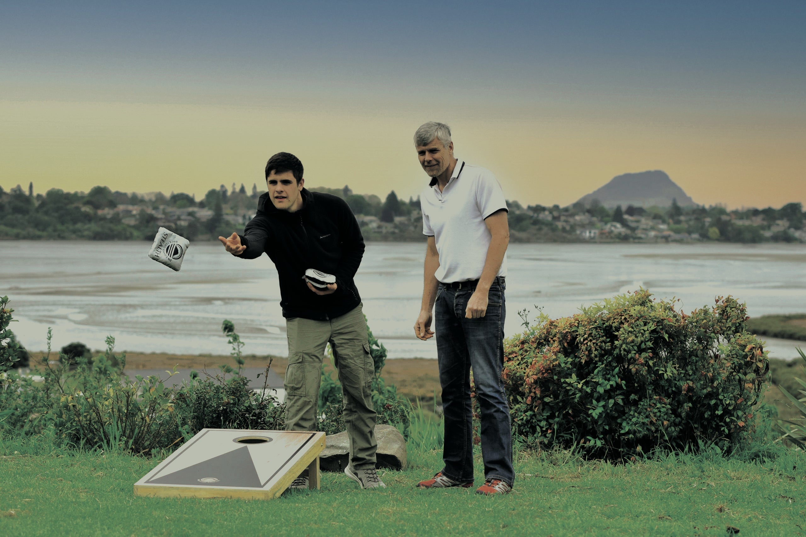 Father and son playing Cornhole in backyard