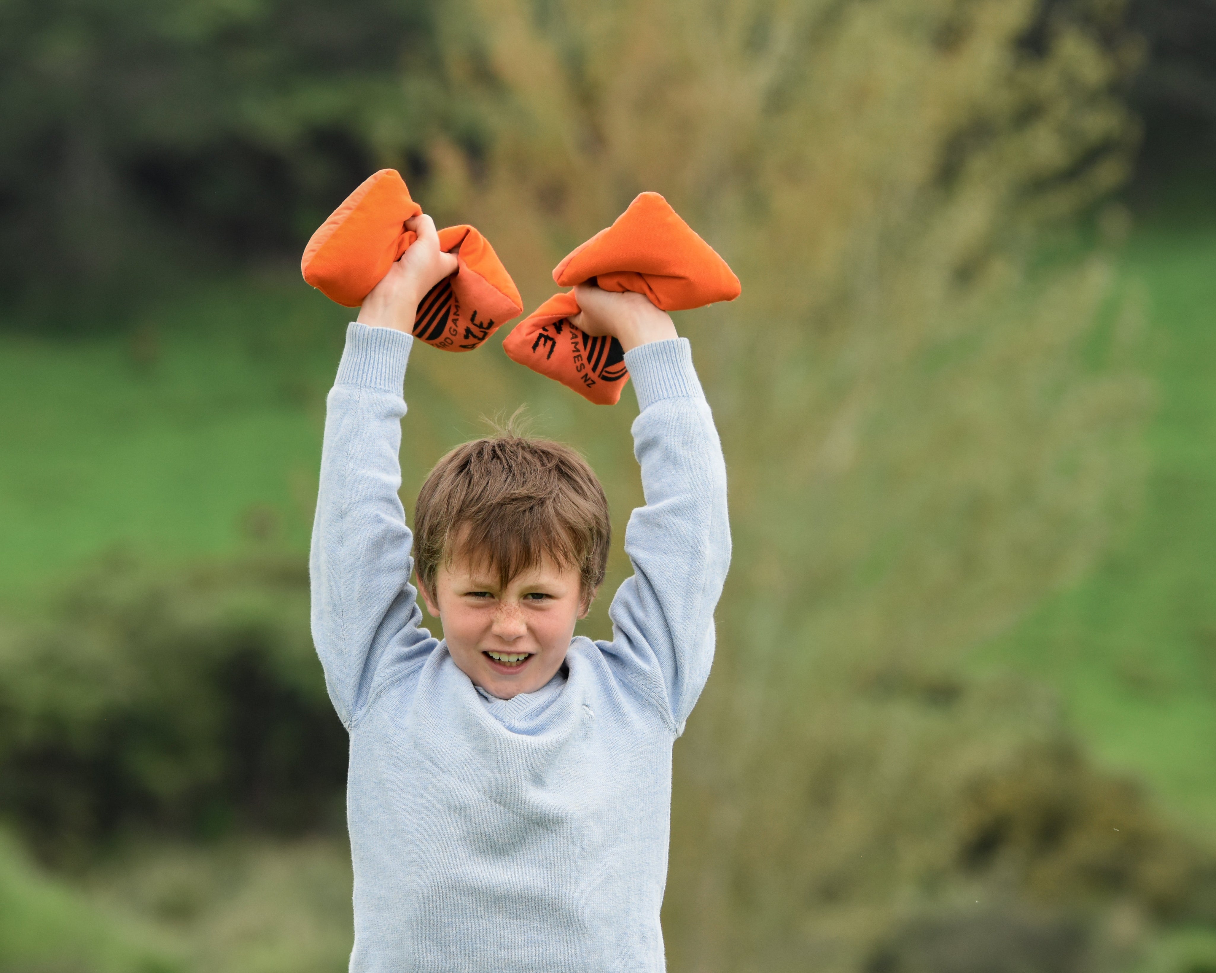 Boy in backyard holding up Backyard Games Cornhole Throwing Bags