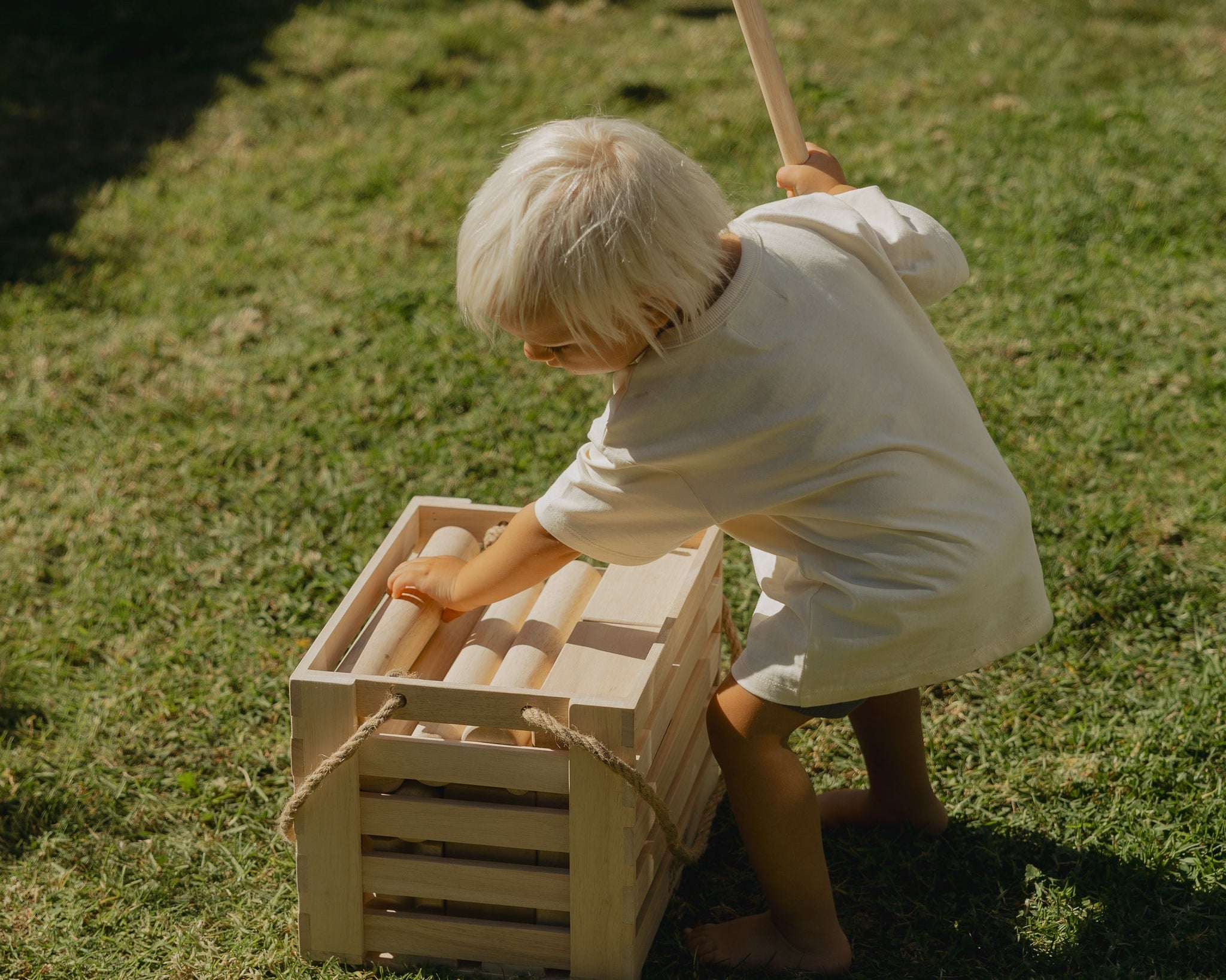 child picking up backyard games nz kubb pieces 