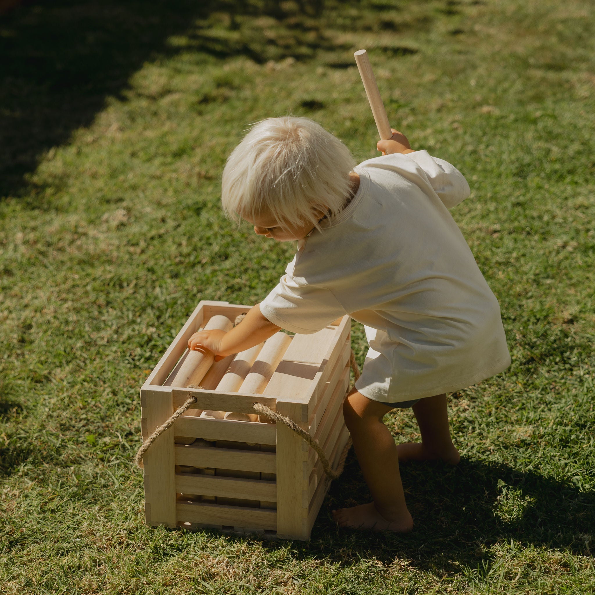 child picking up backyard games nz kubb pieces 