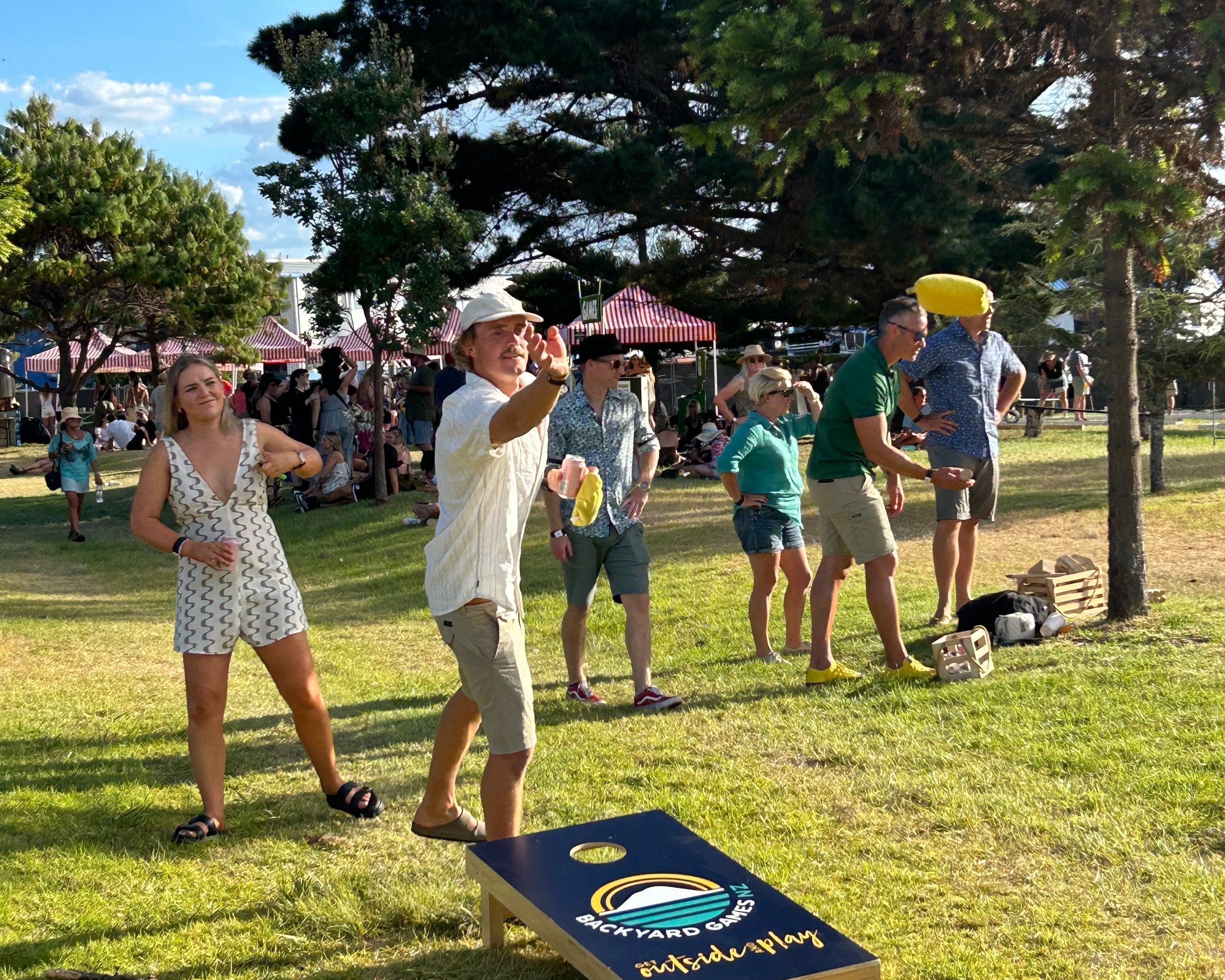 People playing Cornhole at an outdoor event