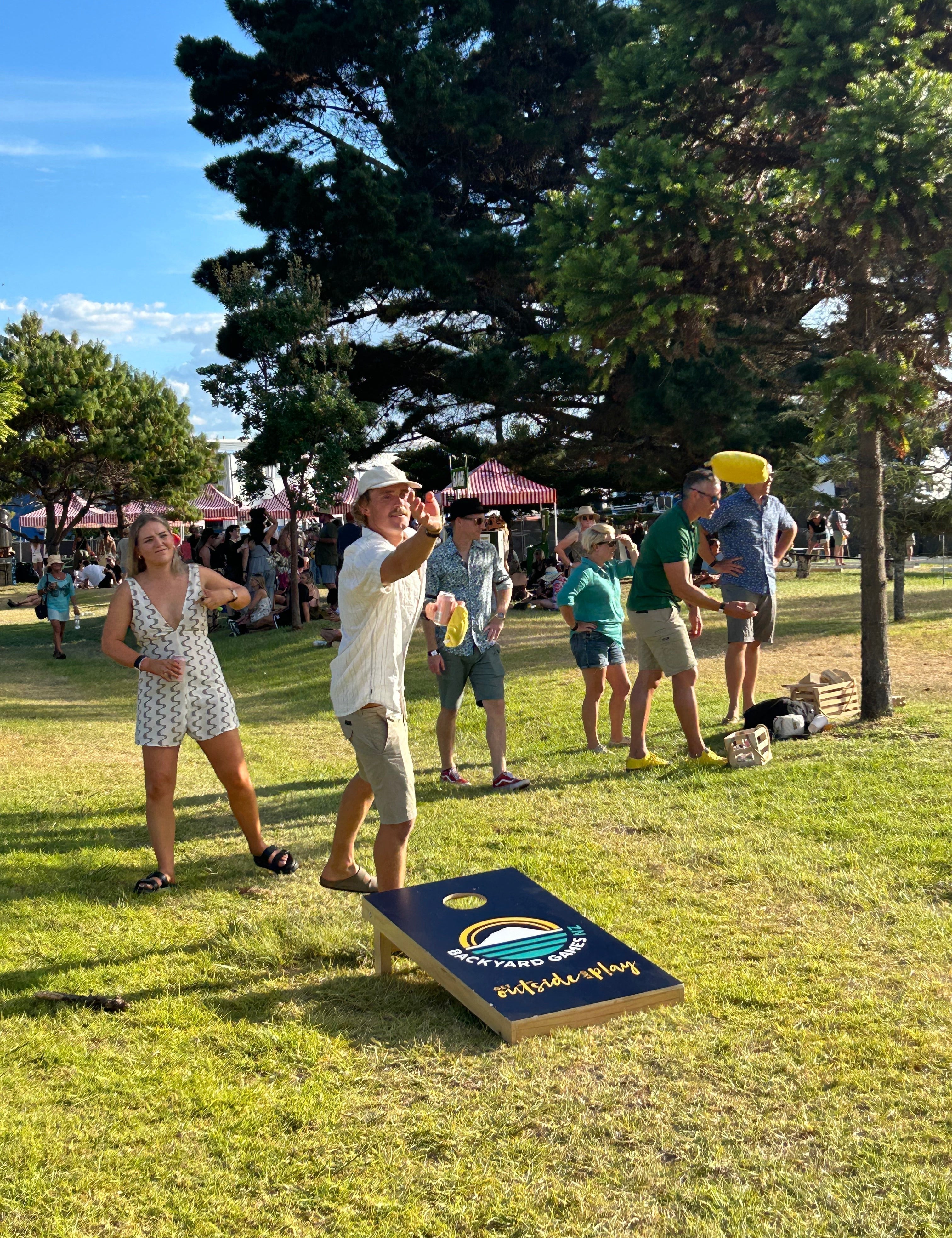 People playing Cornhole at an outdoor event
