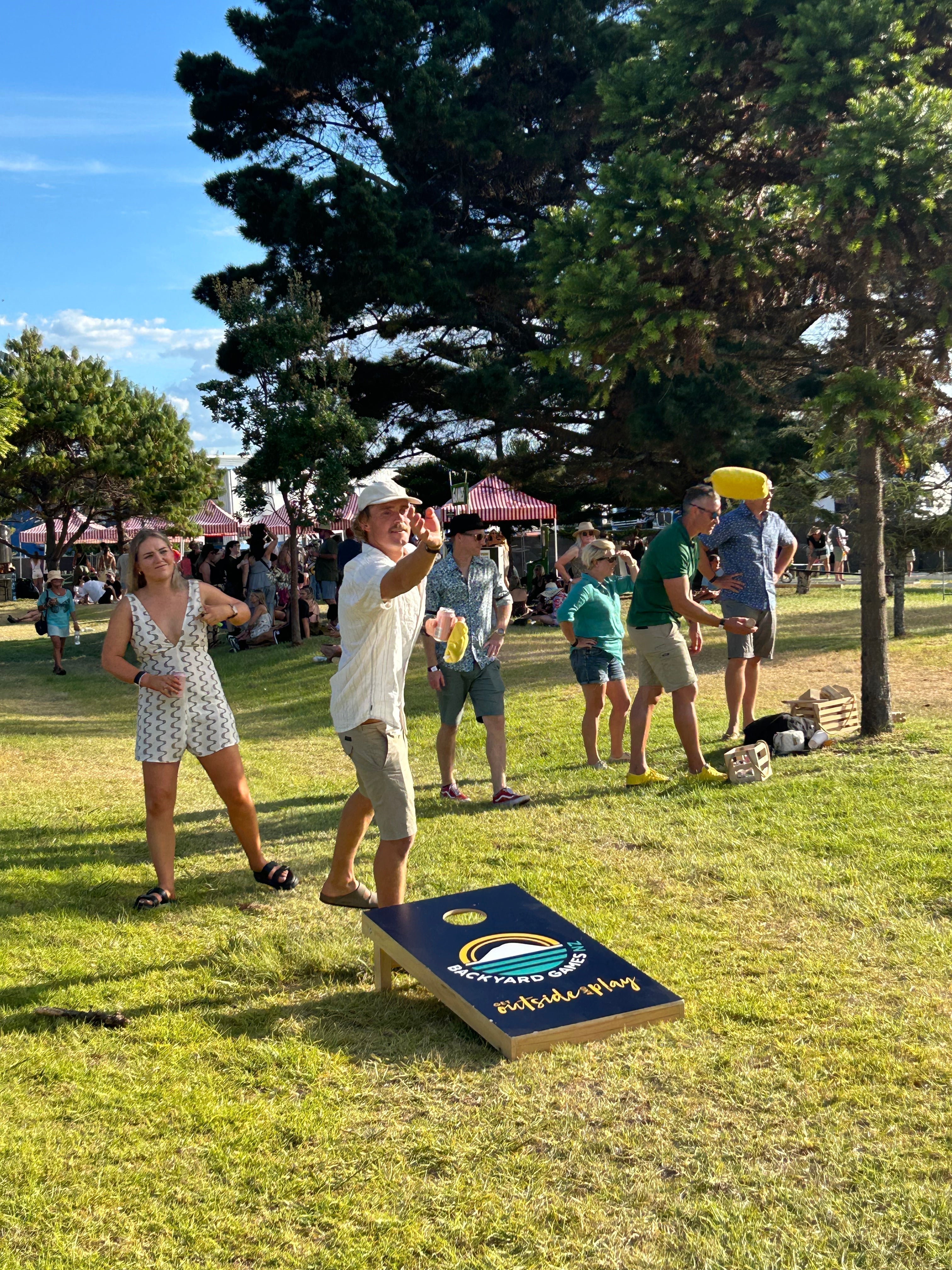 People playing Cornhole at an outdoor event