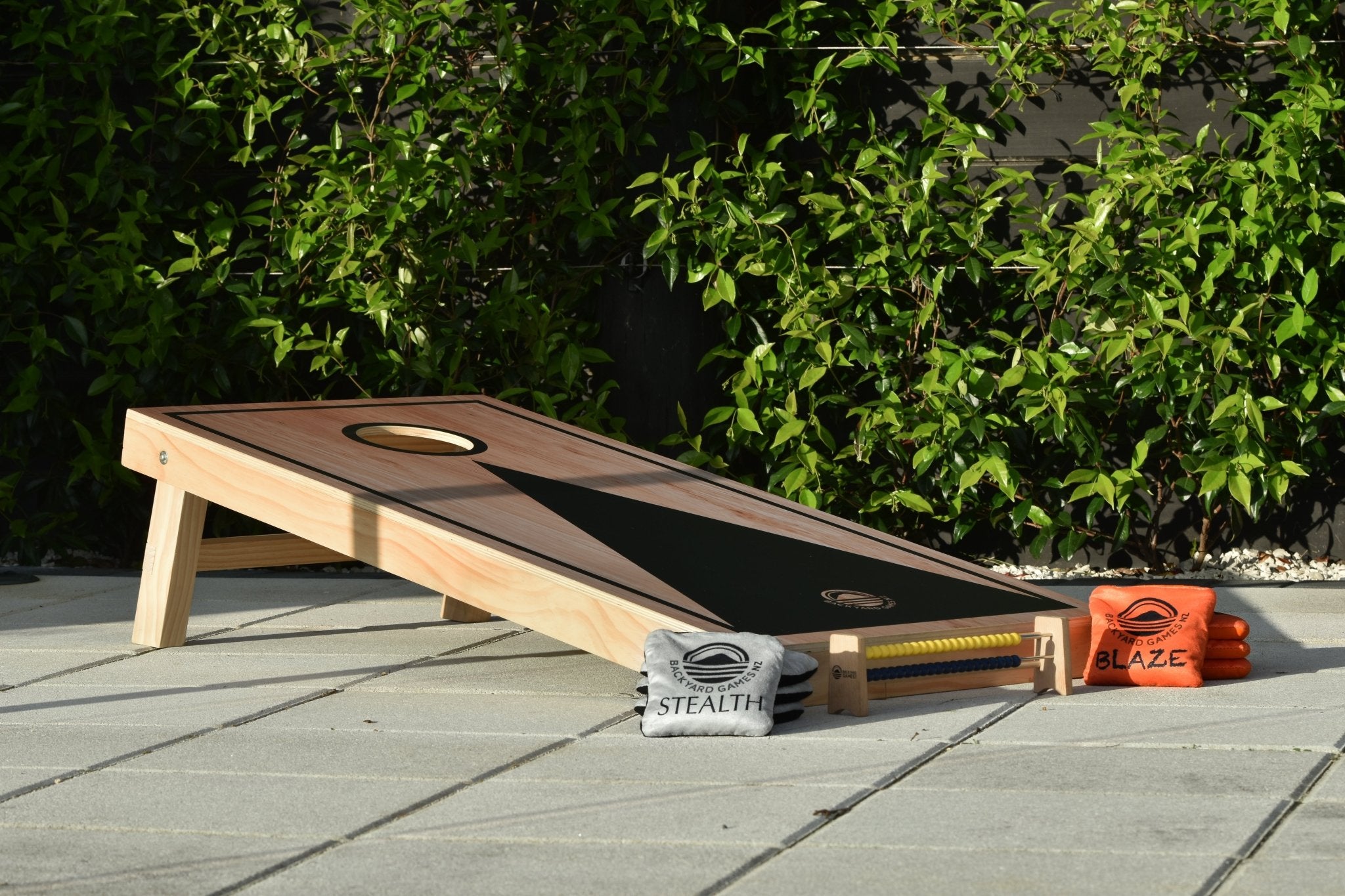 Deluxe Wood Cornhole Set — black-on-wood finish on an outdoor deck