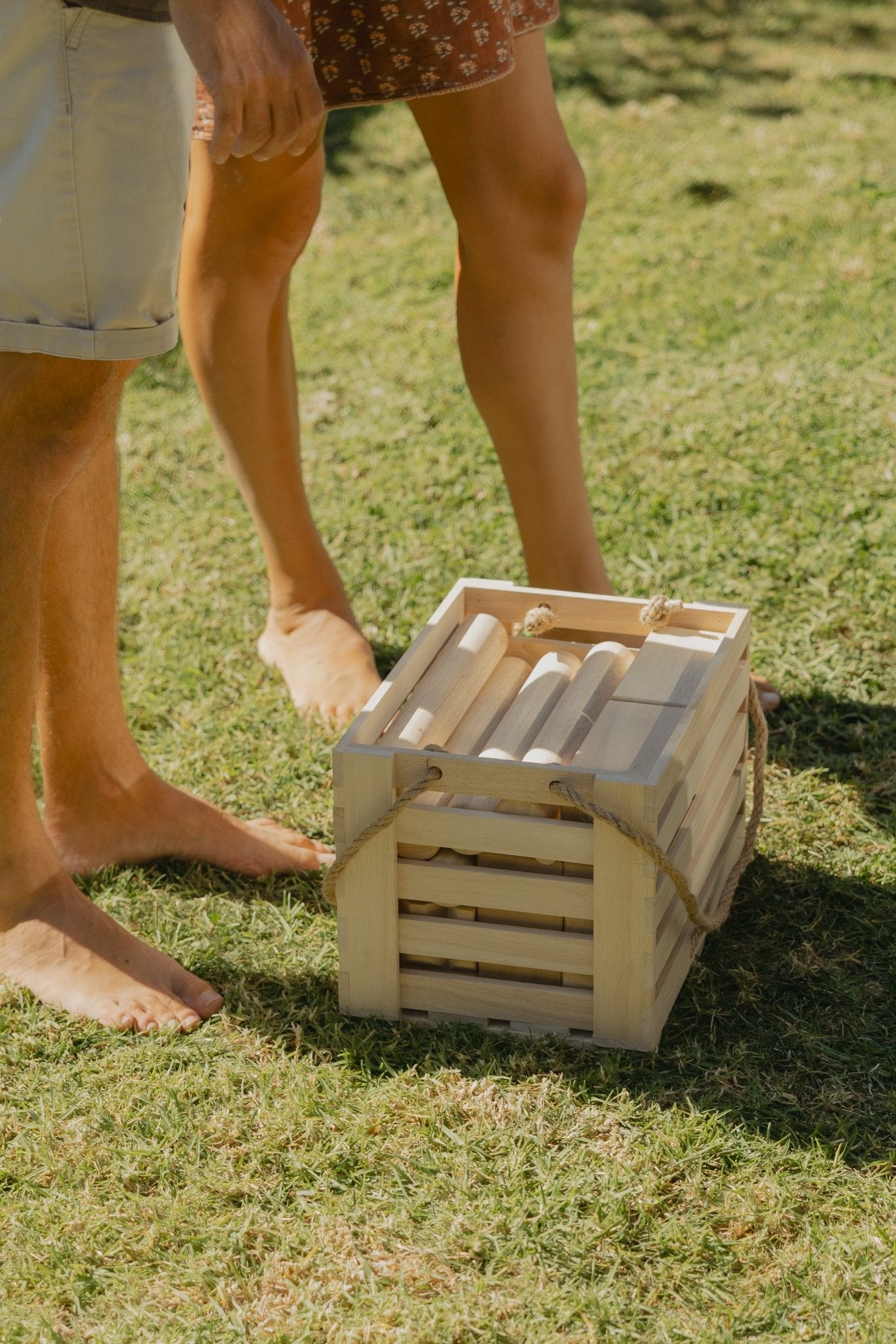 Backyard Games NZ Giant Kubb in crate on grass with people's legs in the background