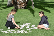 Two Girls Playing Backyard Games Giant Letter Tiles on the lawn