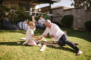 Man and child playing Backyard Games NZ Giant Dominoes on a grassy lawn