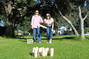 Friends playing wooden Skittles outdoors in NZ backyard