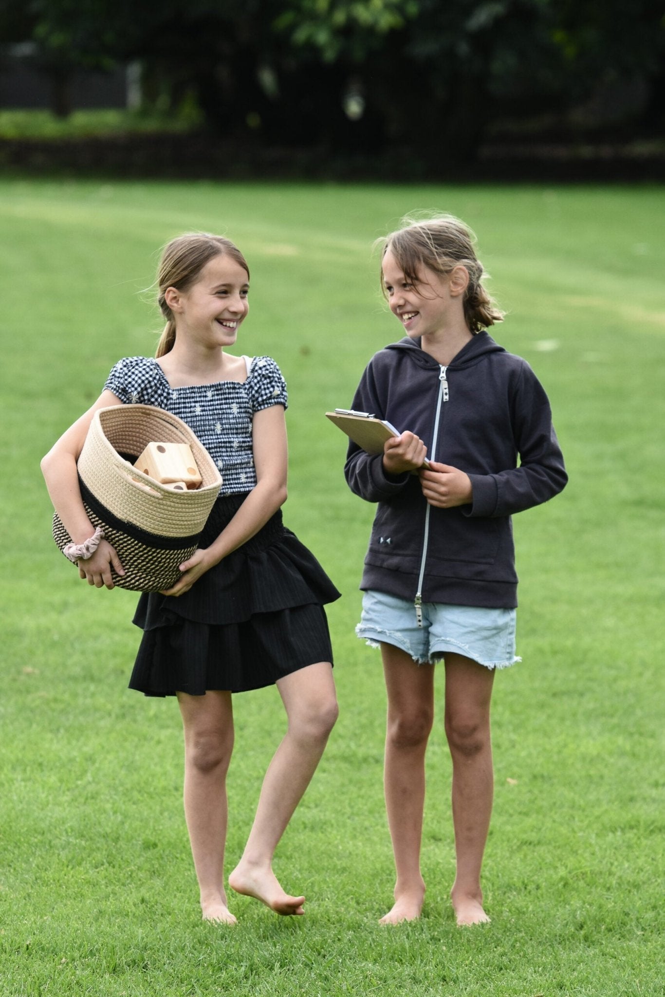girls carrying Yardzee and Farkle wooden dice set in backyard